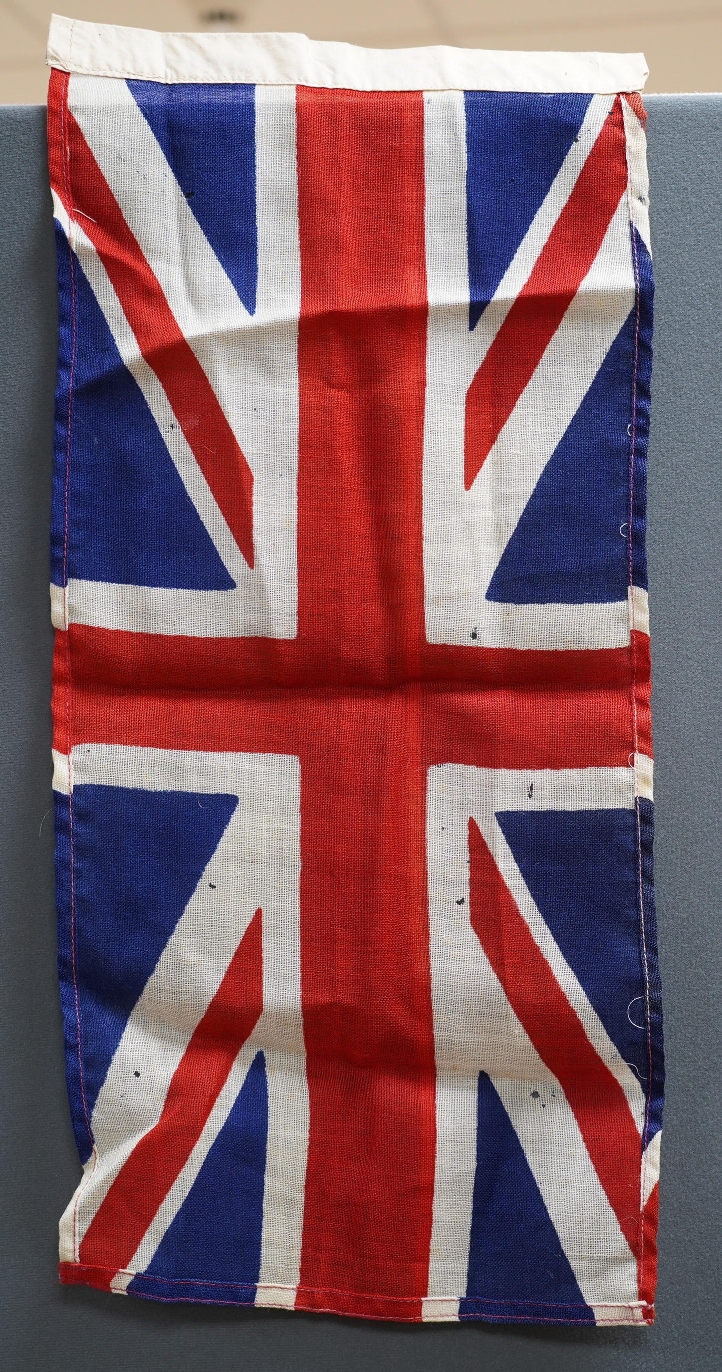 Eight mostly mid 20th century Union Jack flags, one celebrating Queen Victoria’s Diamond Jubilee, together with a Saint George’s cross and a string of Union flag bunting. Condition - poor to good